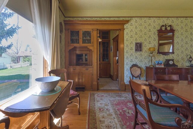 dining room with wallpapered walls and light wood finished floors