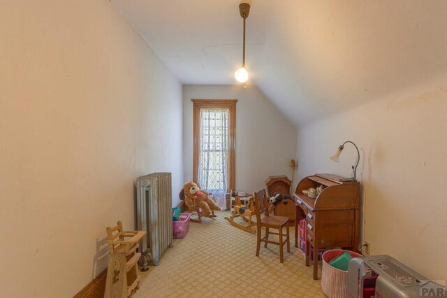 rec room with light carpet, lofted ceiling, and radiator