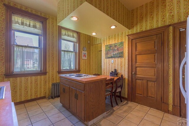 office area with light tile patterned floors, radiator, baseboards, and wallpapered walls