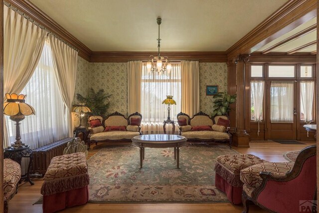 sitting room featuring a notable chandelier, plenty of natural light, and wallpapered walls