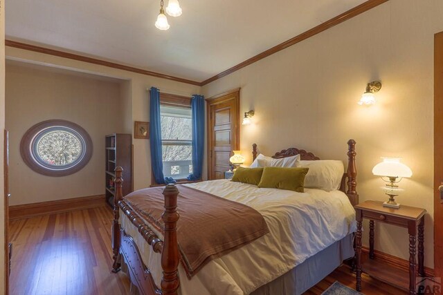 bedroom featuring crown molding, baseboards, and dark wood-type flooring