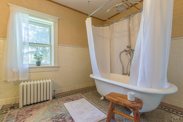 bathroom with ornamental molding, wainscoting, tile walls, and radiator