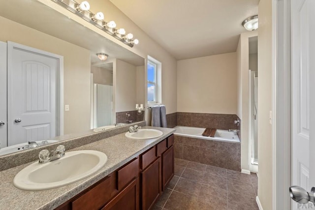 bathroom with tile patterned flooring, a garden tub, a sink, and double vanity