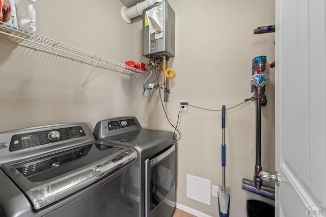 laundry room with laundry area, visible vents, tankless water heater, and washing machine and clothes dryer