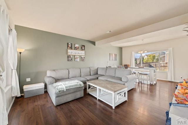 living area with a notable chandelier, dark wood finished floors, and baseboards