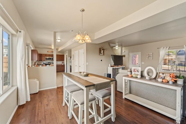 dining room with dark wood-style flooring, visible vents, a notable chandelier, and baseboards