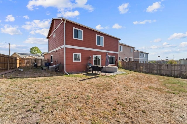 back of property with a patio area, a fenced backyard, and a lawn