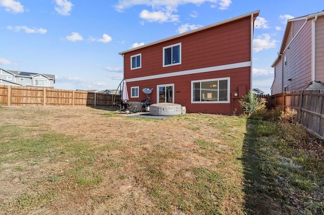 back of house with a fenced backyard and a lawn