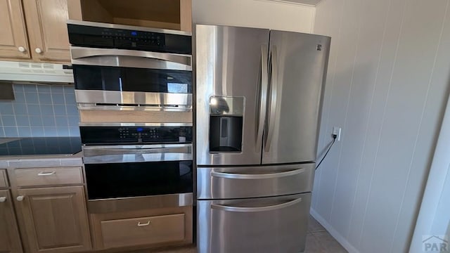232 Saddle Rd, Trinidad, CO 81082 - kitchen with stainless steel appliances, under cabinet range hood, backsplash, tile counters, and light tile patterned floors