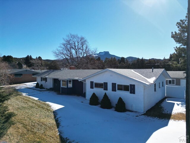 232 Saddle Rd, Trinidad, CO 81082 - view of front facade with a chimney, a mountain view, and board and batten siding