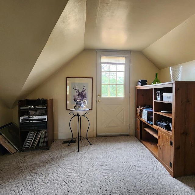 bonus room with lofted ceiling and carpet flooring