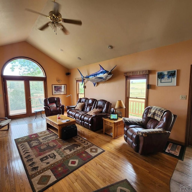 living area with lofted ceiling, a ceiling fan, and light wood-style floors