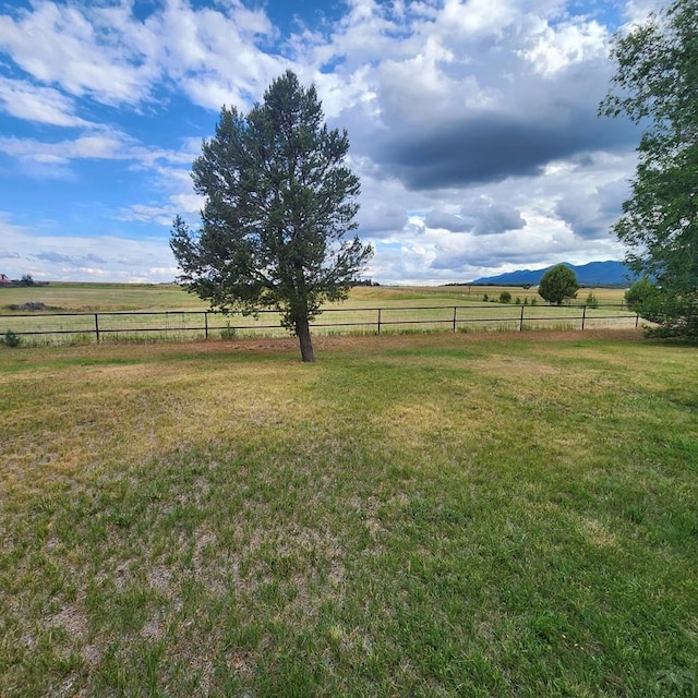 view of yard featuring a rural view and fence