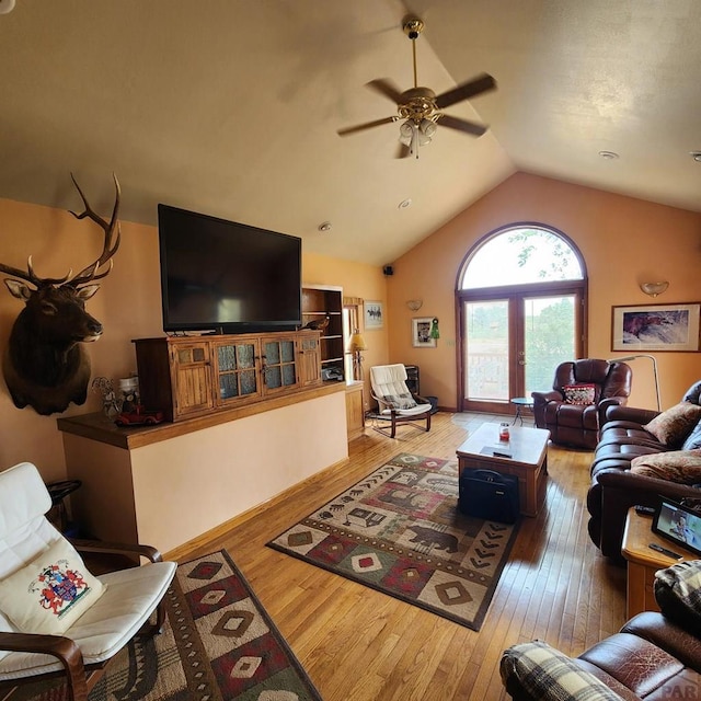 living room featuring lofted ceiling, wood finished floors, and a ceiling fan