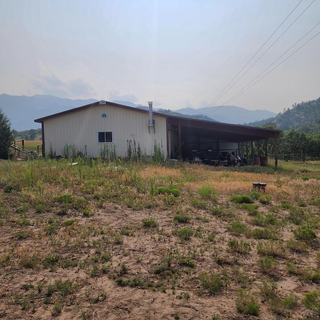 exterior space featuring a carport, an outbuilding, a pole building, and a mountain view