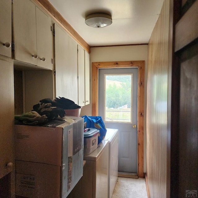 clothes washing area featuring cabinet space and washing machine and clothes dryer