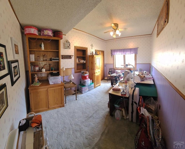 home office with a wainscoted wall, a textured ceiling, carpet flooring, and wallpapered walls