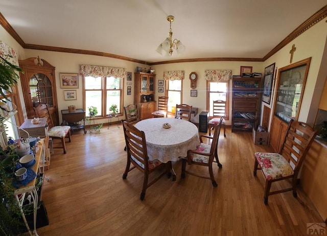 dining room featuring ornamental molding, wood finished floors, and a notable chandelier