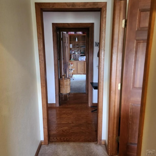 hallway with carpet floors and baseboards