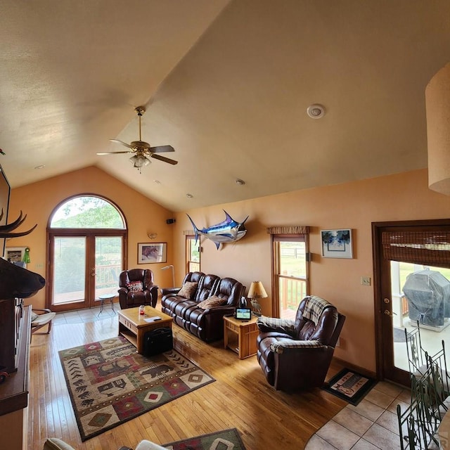 living area with lofted ceiling, ceiling fan, and light wood-style flooring