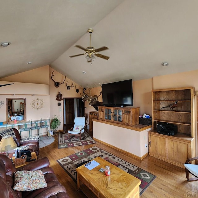 living room with a ceiling fan, lofted ceiling, and light wood-style flooring