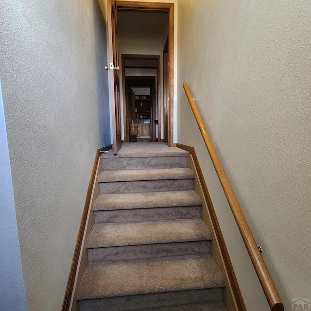 stairway featuring a textured wall