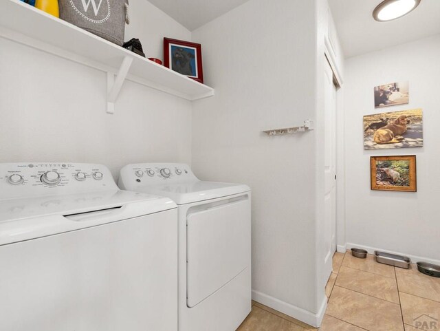 laundry room featuring light tile patterned floors, laundry area, independent washer and dryer, and baseboards