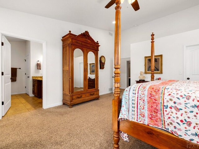 bedroom featuring visible vents, a ceiling fan, light carpet, ensuite bath, and baseboards