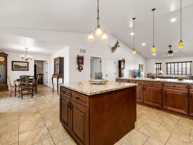 kitchen featuring open floor plan, visible vents, decorative light fixtures, and a center island