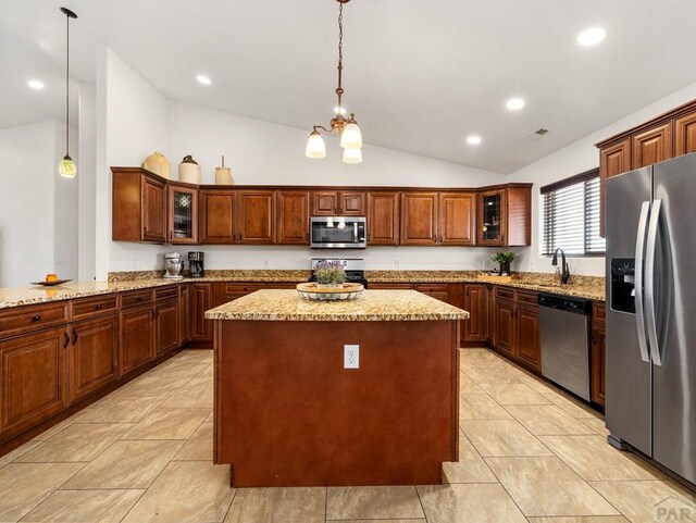 kitchen with stainless steel appliances, pendant lighting, glass insert cabinets, and a kitchen island