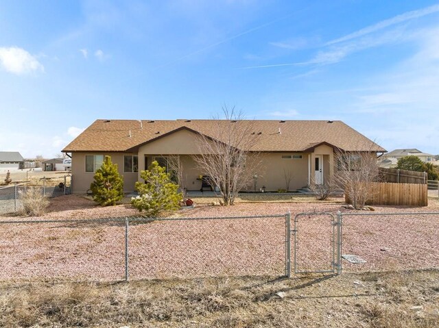 view of front of home featuring fence private yard, a gate, and stucco siding