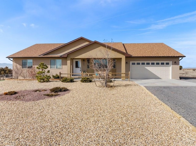 ranch-style house featuring a garage, roof with shingles, driveway, and stucco siding