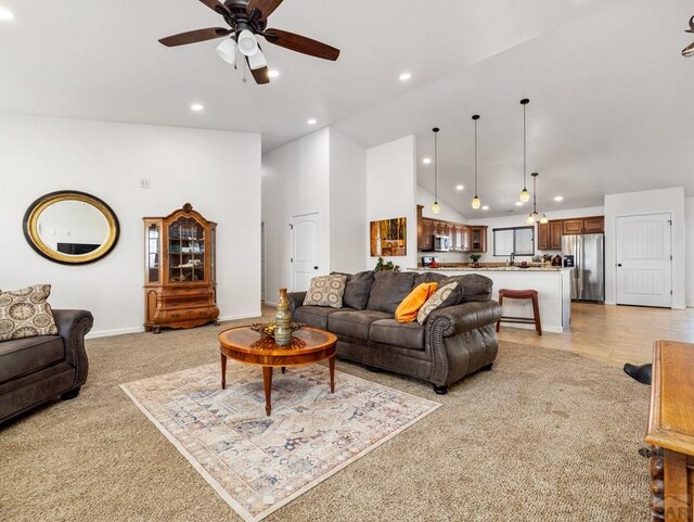 living room with recessed lighting, a ceiling fan, light carpet, high vaulted ceiling, and baseboards