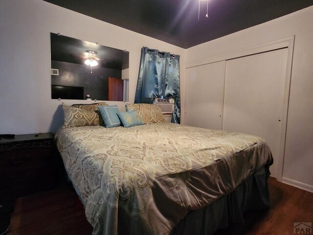 bedroom with ceiling fan, a closet, and dark wood-style flooring