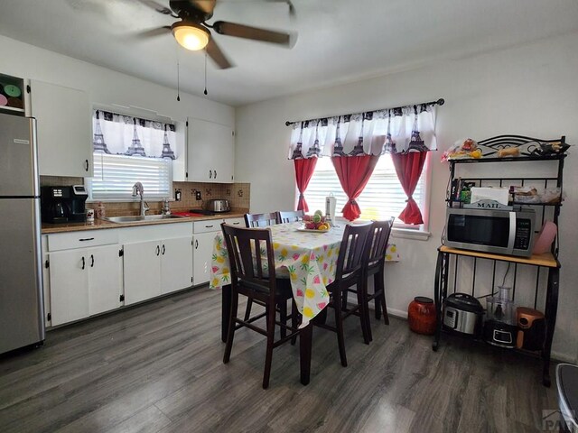 dining space featuring dark wood-style floors, plenty of natural light, and a ceiling fan