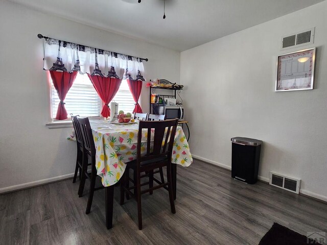 dining area featuring dark wood finished floors, visible vents, and baseboards