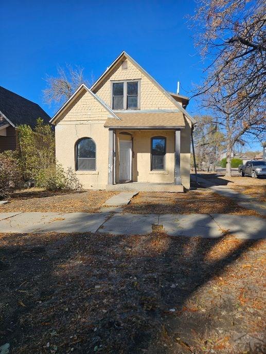 view of front facade with a porch and stucco siding