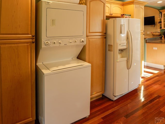 709 Cimarron Ave, La Junta, CO 81050 - washroom with estacked washer and dryer and dark wood-type flooring
