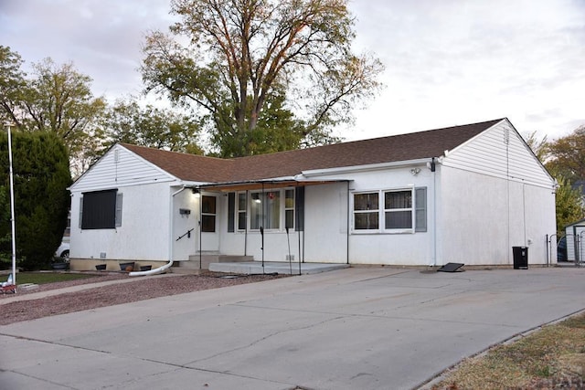 single story home featuring a porch and a shingled roof