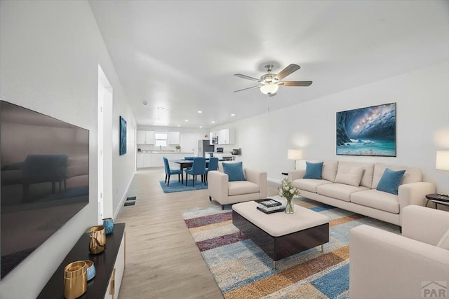 living area featuring a ceiling fan, visible vents, baseboards, recessed lighting, and light wood-style flooring