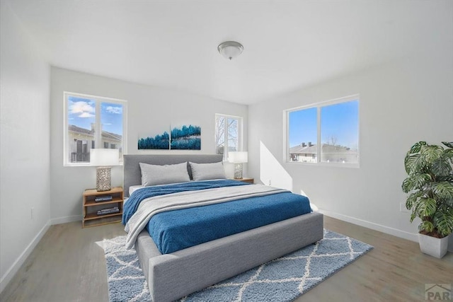 bedroom with baseboards and wood finished floors