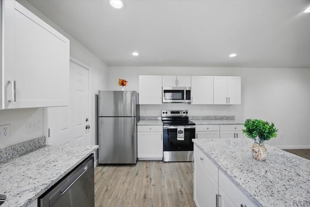 kitchen with stainless steel appliances, recessed lighting, and white cabinetry