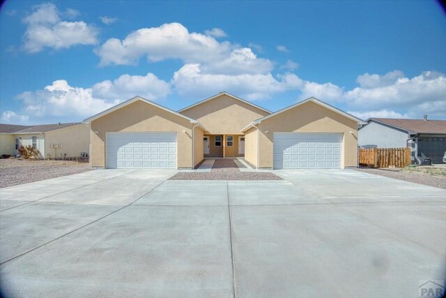 single story home with fence, an attached garage, driveway, and stucco siding
