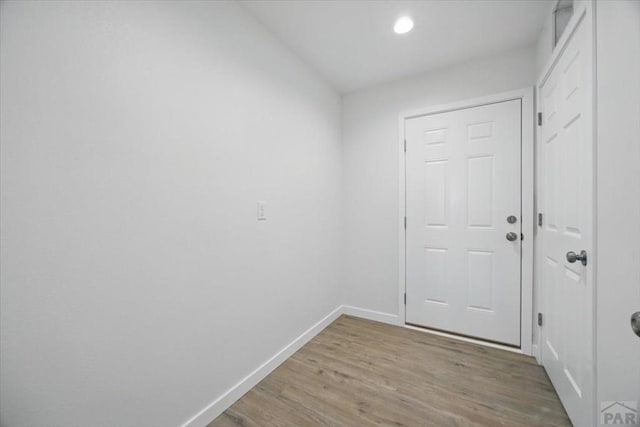 doorway featuring baseboards, recessed lighting, and wood finished floors