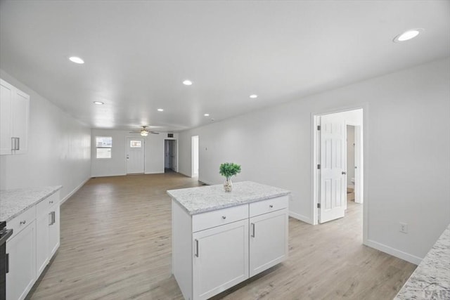 kitchen featuring a ceiling fan, recessed lighting, white cabinetry, light wood-type flooring, and a kitchen island