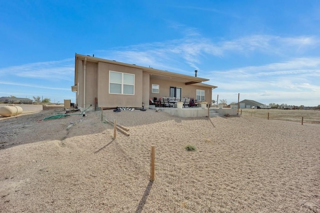 back of house featuring stucco siding, fence, and a patio