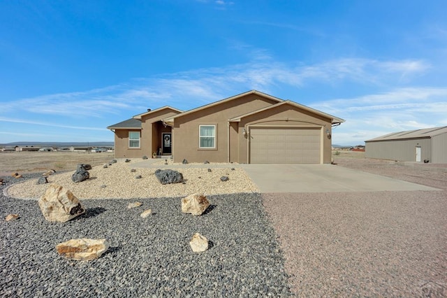 view of front of home with a garage, stucco siding, and concrete driveway