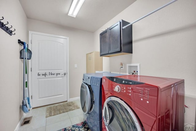 washroom featuring washing machine and dryer, baseboards, light tile patterned floors, and cabinet space