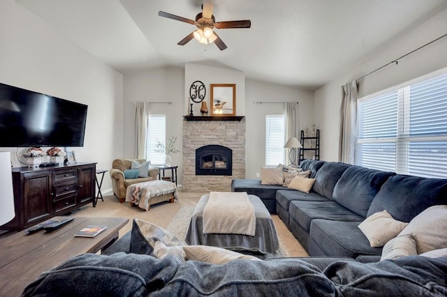 living room featuring a fireplace, vaulted ceiling, a wealth of natural light, and ceiling fan
