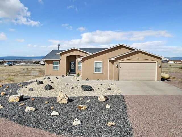 view of front of house featuring an attached garage, stucco siding, and driveway